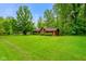 Expansive front yard view of this charming home with well-manicured lawn, mature trees, and inviting curb appeal at 6794 E Ann St, Camby, IN 46113