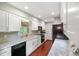 Galley kitchen with white cabinets, stainless steel appliances, and wood floors at 6794 E Ann St, Camby, IN 46113