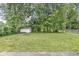 Backyard featuring a shed and large mature trees and grass at 7503 Grandview Dr, Indianapolis, IN 46260