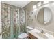 The bathroom features a decorated shower curtain, vanity with a mirror, and modern light fixture at 7503 Grandview Dr, Indianapolis, IN 46260