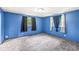 Bright bedroom featuring blue walls, carpet floors, and well-lit windows with curtains at 7503 Grandview Dr, Indianapolis, IN 46260