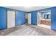 Spacious main bedroom featuring blue walls, neutral carpet, and an ensuite bathroom for added convenience and privacy at 7503 Grandview Dr, Indianapolis, IN 46260