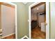 Hallway view into the laundry room and half-bath, featuring tiled floors and neutral paint at 7604 Cloudy Ct, Camby, IN 46113