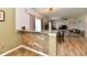 A granite breakfast bar overlooks an open-concept living room with sliding glass doors and neutral paint at 7604 Cloudy Ct, Camby, IN 46113