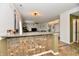 An open-concept living room featuring a granite breakfast bar, access to the stairs, and neutral paint at 7604 Cloudy Ct, Camby, IN 46113