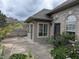 Exterior view of home featuring flower bushes, stone, and enclosed sunroom at 7645 Briarstone Ln, Indianapolis, IN 46227