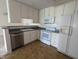 Kitchen with white appliances and cabinets, modern fixtures, and tile flooring at 7645 Briarstone Ln, Indianapolis, IN 46227