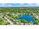 A picturesque aerial view of homes nestled around a tranquil lake surrounded by lush greenery and neighborhood streets at 7670 Lippincott Way, Indianapolis, IN 46268