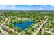 Expansive aerial view highlighting a community near a lake, lush greenery, and distant city skyline at 7670 Lippincott Way, Indianapolis, IN 46268