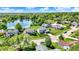 An aerial perspective of a suburban neighborhood dotted with well-manicured lawns and a tranquil lake at 7670 Lippincott Way, Indianapolis, IN 46268