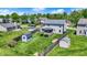 A large backyard with green grass, several storage sheds and partial privacy fencing at 7670 Lippincott Way, Indianapolis, IN 46268