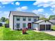 Charming two-story home features a red front door, attached two-car garage and well-manicured lawn at 7670 Lippincott Way, Indianapolis, IN 46268