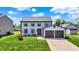 Charming two-story home with a two-car garage, a vibrant lawn, and a welcoming red front door at 7670 Lippincott Way, Indianapolis, IN 46268