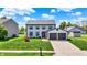 Charming two-story home with a red door, attached garage, and pristine landscaping at 7670 Lippincott Way, Indianapolis, IN 46268