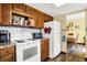 Kitchen featuring wood cabinets and white appliances overlooking eat-in area at 7670 Lippincott Way, Indianapolis, IN 46268