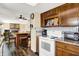 Traditional kitchen featuring wood cabinets, white appliances, and a breakfast bar at 7670 Lippincott Way, Indianapolis, IN 46268