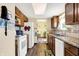 Galley kitchen featuring wood cabinets, white appliances and wood floors at 7670 Lippincott Way, Indianapolis, IN 46268