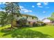 Expansive backyard displays a manicured lawn and a two-story home with charming stone accents and a small patio at 781 Dayton Dr, Carmel, IN 46033