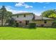 Well maintained backyard features a stone-accented home, a lush lawn, and patio with a small outdoor table at 781 Dayton Dr, Carmel, IN 46033