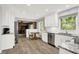 Bright kitchen offers stainless appliances, white cabinetry, granite countertops, and wood look floors at 781 Dayton Dr, Carmel, IN 46033