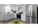 Well-lit kitchen with stainless steel appliances, white cabinets, and modern fixtures at 7835 E 50Th St, Indianapolis, IN 46226