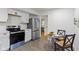 Modern kitchen features stainless steel appliances, white cabinetry, and a cozy dining area with table and chairs at 7835 E 50Th St, Indianapolis, IN 46226