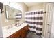 Well-lit bathroom features a double sink vanity with wood cabinets and a shower with a striped curtain at 7895 E 175 N, Franklin, IN 46131