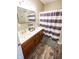 Well-lit bathroom features a double sink vanity with wood cabinets and a shower with a striped curtain at 7895 E 175 N, Franklin, IN 46131