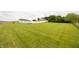 Expansive green lawn surrounded by trees and featuring a white barn and main house at 7895 E 175 N, Franklin, IN 46131