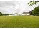 Expansive green lawn with trees and featuring a white barn and main house at 7895 E 175 N, Franklin, IN 46131