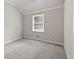 This bedroom is empty and has a gray carpet and a window at 8029 Castle Lake Rd, Indianapolis, IN 46256