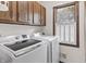 Laundry room featuring a washer, dryer, and wooden cabinets at 8029 Castle Lake Rd, Indianapolis, IN 46256
