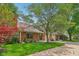 Charming brick home with mature trees, an attached garage, and a well-maintained lawn at 9054 Cinnebar Dr, Indianapolis, IN 46268