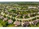 Aerial view of a residential neighborhood with lush greenery, a lake, and well-maintained homes at 9311 Windrift Way, Zionsville, IN 46077