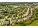 Aerial view of a residential neighborhood with lush greenery, a lake, and well-maintained homes at 9311 Windrift Way, Zionsville, IN 46077
