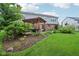 Beautiful backyard with covered patio, manicured lawn, and established landscaping at 9311 Windrift Way, Zionsville, IN 46077