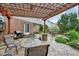 Outdoor dining patio area with pergola, grill, and mature landscaping in the backyard at 9311 Windrift Way, Zionsville, IN 46077