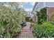 Lush backyard with stone pathway leading to a covered patio and outdoor dining area at 9311 Windrift Way, Zionsville, IN 46077