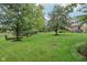 Large backyard with green lawn and mature trees providing shade and privacy at 9311 Windrift Way, Zionsville, IN 46077