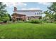 Spacious backyard featuring a patio with pergola, mature trees, and manicured lawn at 9311 Windrift Way, Zionsville, IN 46077