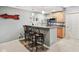Basement bar area features granite countertops, stainless steel appliances, and seating for three at 9311 Windrift Way, Zionsville, IN 46077