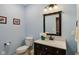 Powder room with attractive vanity, decorative mirror, and soft blue walls at 9311 Windrift Way, Zionsville, IN 46077