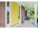 Inviting front porch featuring a vibrant yellow door and comfortable seating at 9311 Windrift Way, Zionsville, IN 46077