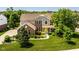 Beautiful two-story home with a well-manicured lawn and colorful landscaping with a bright yellow front door at 9311 Windrift Way, Zionsville, IN 46077