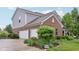 Attached three car garage with lush landscaping around the side and back at 9311 Windrift Way, Zionsville, IN 46077