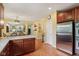 Open-concept kitchen with wood cabinets, stainless steel appliances, and seamless flow to dining and living areas at 9311 Windrift Way, Zionsville, IN 46077