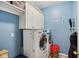 Efficient laundry room includes a washer, dryer, overhead cabinets, and organized storage solutions at 9311 Windrift Way, Zionsville, IN 46077