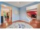 Open living room featuring hardwood floors, light blue walls, and seamless access to other living spaces at 9311 Windrift Way, Zionsville, IN 46077