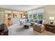 Bright and airy living room with a large sectional sofa and a view of the kitchen at 9311 Windrift Way, Zionsville, IN 46077