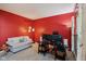 Home office with red walls, neutral carpet, a white couch, and a work station with dual monitors at 9311 Windrift Way, Zionsville, IN 46077
